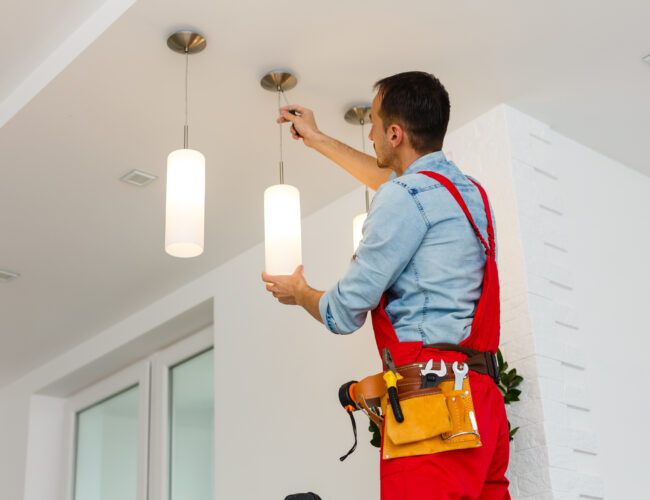 Electrician man worker installing ceiling lamp Electrician man worker installing ceiling lamp